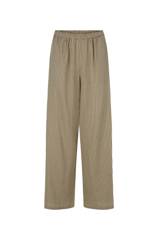  wearing a brown patterned short-sleeve top and beige wide-leg trousers.
