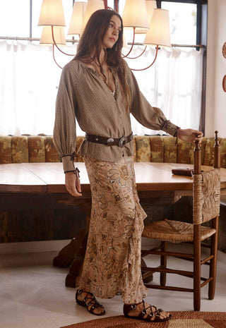  set against a rustic background with a patterned gold and brown velvet sofa.